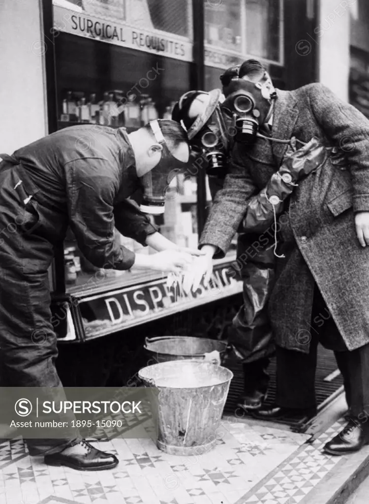 ´Chemists have arranged to have bleach paste ready in a gas attack. This man is being treated for splashes on his hand. His respirator has protected h...
