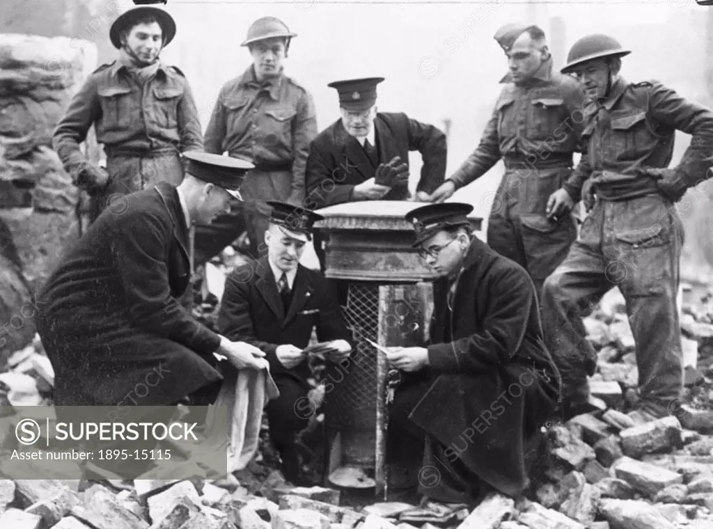 ´Postmen sorting letters from a box salvaged from underneath bombed debris in London. They were all intact´.