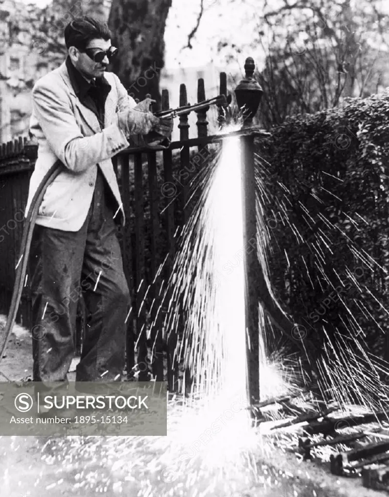 A workman is using an acetylene burner on the Duke of Bedford´s railings in Russell Square, London. The metal was to be used to make aeroplanes´.