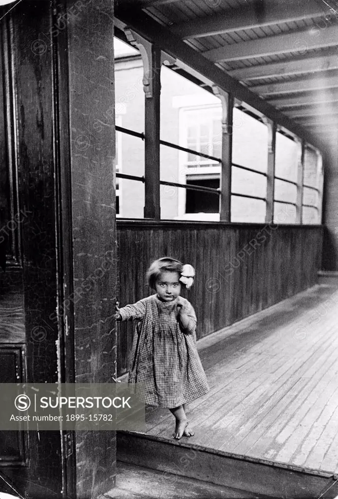 Small girl, USA, c 1910s Barefoot child, probably from an immigrant family living in a tenement building  Photograph taken by Lewis Wickes Hine 1874-1...