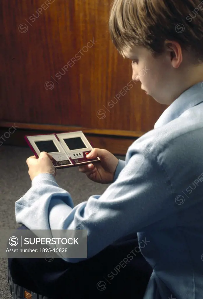 Gabriel Bailey playing ´Mario Bros´ on a Nintendo hand-held computer.