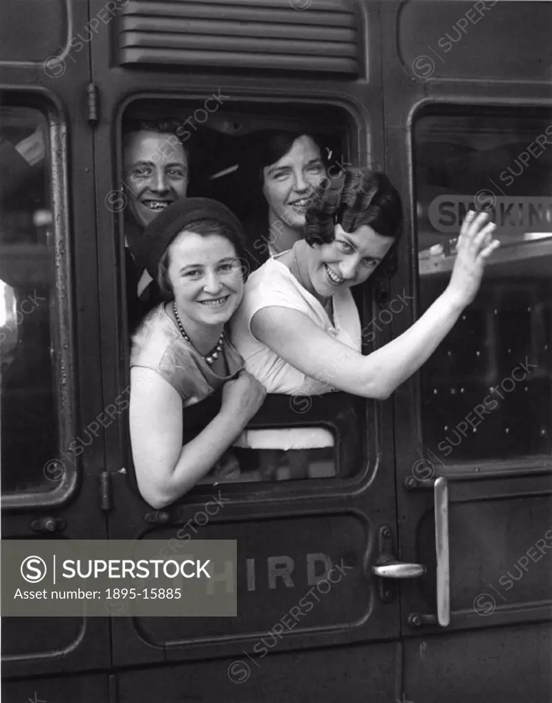 Women waving goodbye from a third class carriage window at Victoria Station. Photograph by Harold Tomlin for the Daily Herald newspaper.
