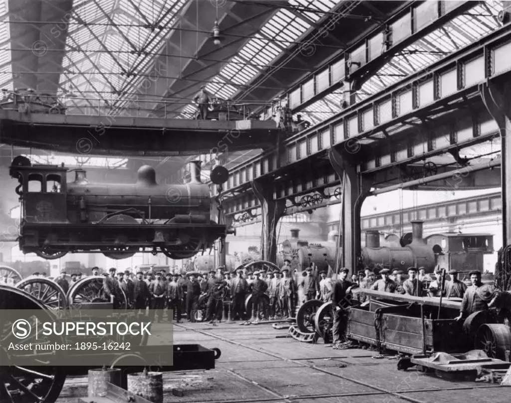 Crowds watching a suspended locomotive at the North Eastern Railway´s Gateshead Works.