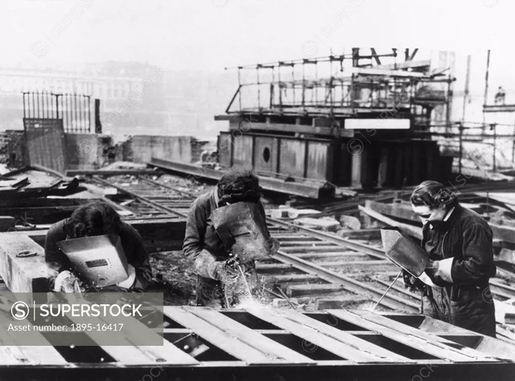 ´Girl acetylene welders were at their job as usual today, cutting the girders of the temporary Waterloo Bridge, which is being dismantled.´ Photograph...