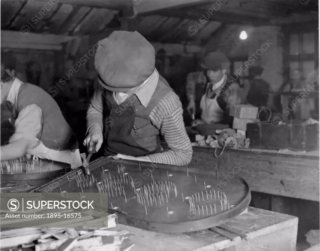 A group of workmen making bagatelle boards at the Coronation company works in Hoxton, East London on 14 December 1932. This was a very popular board g...