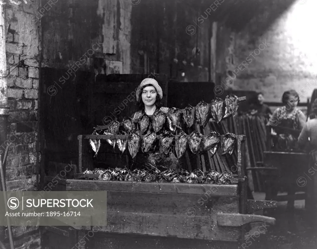 Kipper girl displaying smoked kippers, Newhaven, Edinburgh, Scotland, 24 September 1931. This photograph was taken for a series of articles called ´In...