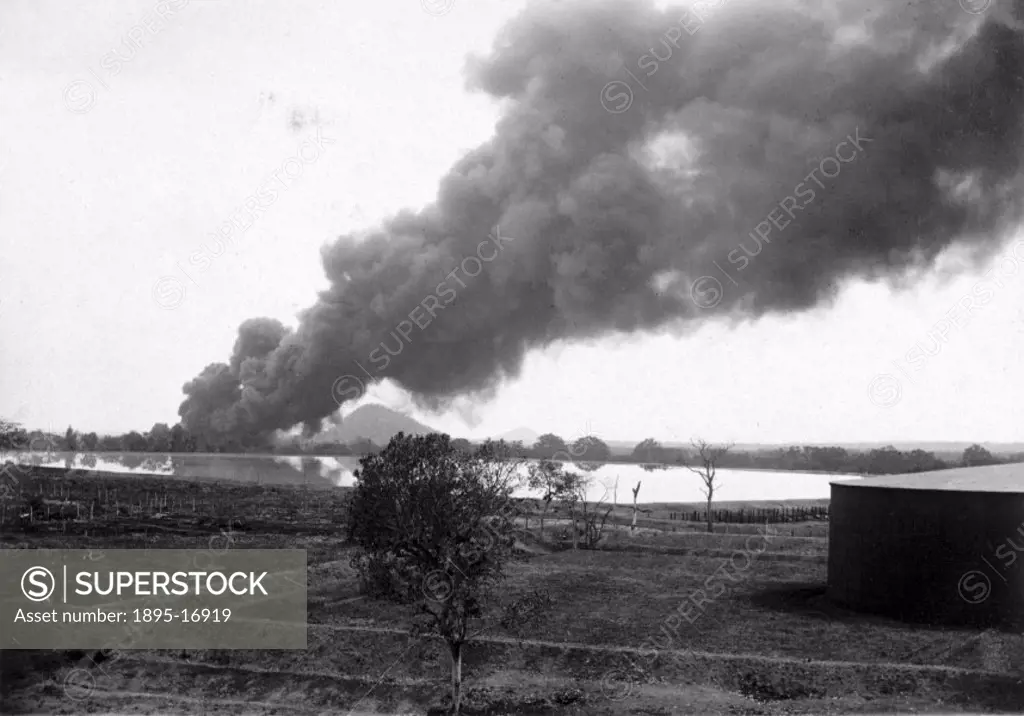 Photograph of a huge column of black smoke rising from a burning oil storage tank in the Potrero oil fields in Mexico. This fire happened at one of th...
