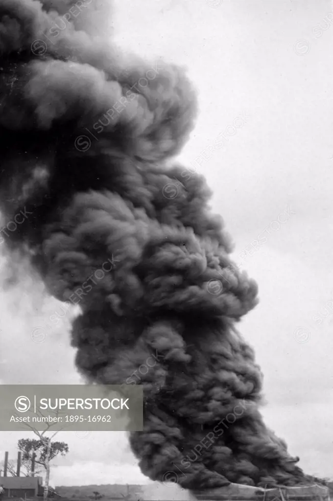 Photograph of a huge column of black smoke rising from a burning oil storage tank in the Potrero oil fields in Mexico. This fire happened at one of th...