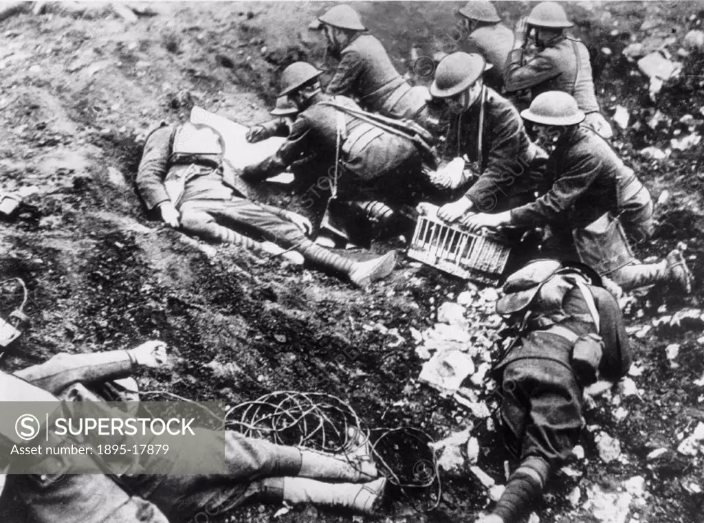 Advance post of American troops preparing to send a message to headquarters by pigeon courier. Photograph taken in a shell hole with casualties, near ...