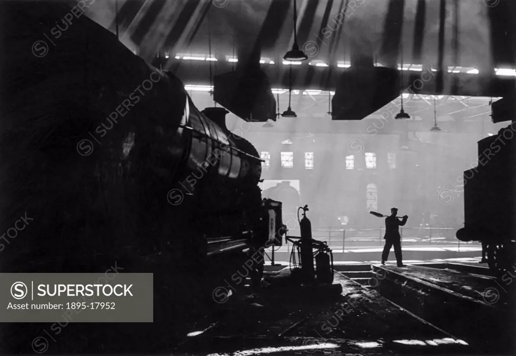 Jubilee´ class 4-6-0 locomotive No 45697 ´Achilles´ in Holbeck shed. The locomotives ranged around the turntable and shafts of light cutting through ...
