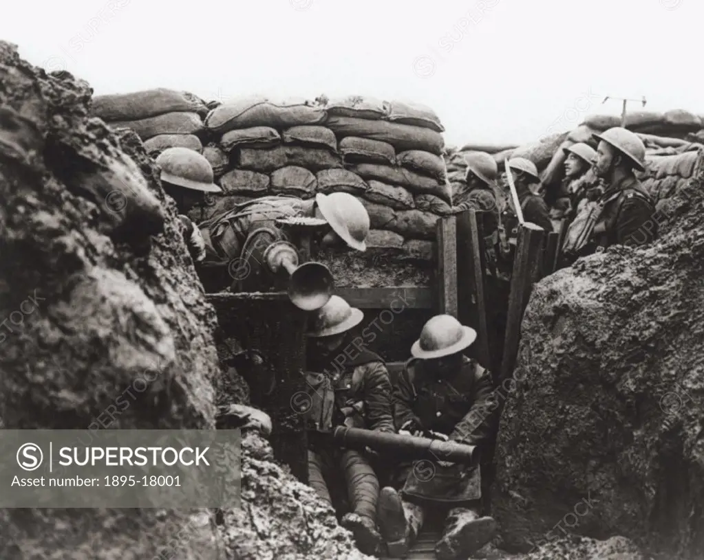Lancashire Fusiliers in a front line trench, Ploegsteert Wood, Messines, January 1917. Inside the trench, one soldier is cleaning his Lewis gun and th...