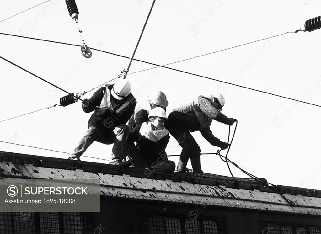 Electrification of the East Coast Main Line between London and Scotland  The workers on the roof of the electrification train are tying off the catena...