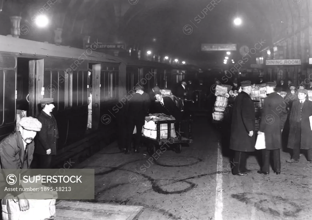 Newspapers being loaded into train vans at midnight, Paddington station, 10 December 1910  The coming of the Railways made it possible for national ne...