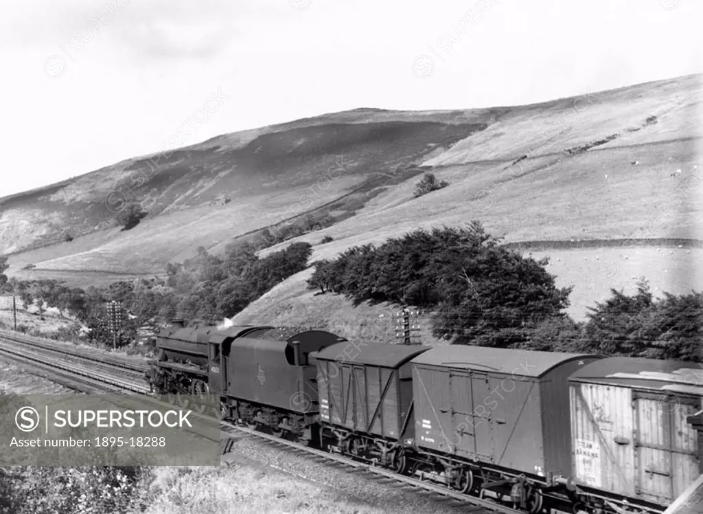 Class 5 4-6-0 locomotive No 45133 heads north through the Lune Gorge, passing over Dillicar water troughs, with a train of banana vans. The legend ´st...