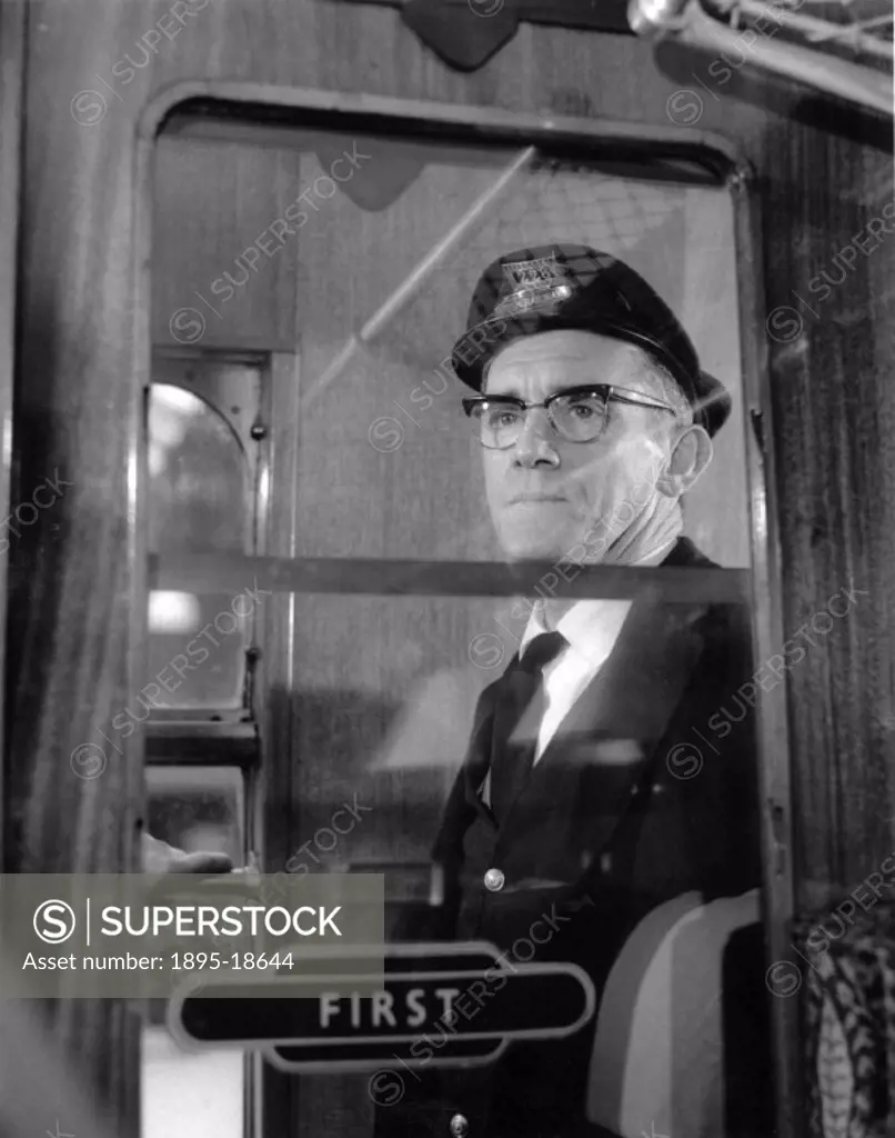 The British Railways´ porter is looking out of the window of a First Class carriage.