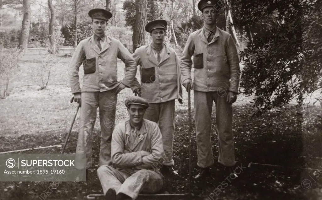 Postcard of a group of wounded British soldiers posing for a photograph in the grounds of Queen Mary´s Convalescent Auxiliary Hospital, Roehampton, Lo...