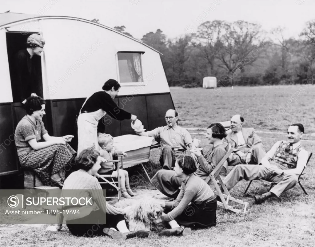 Members of the caravan section of the Camping Club of Great Britain taking tea in a field, c 1950s. Photograph by Reuben Saidman.