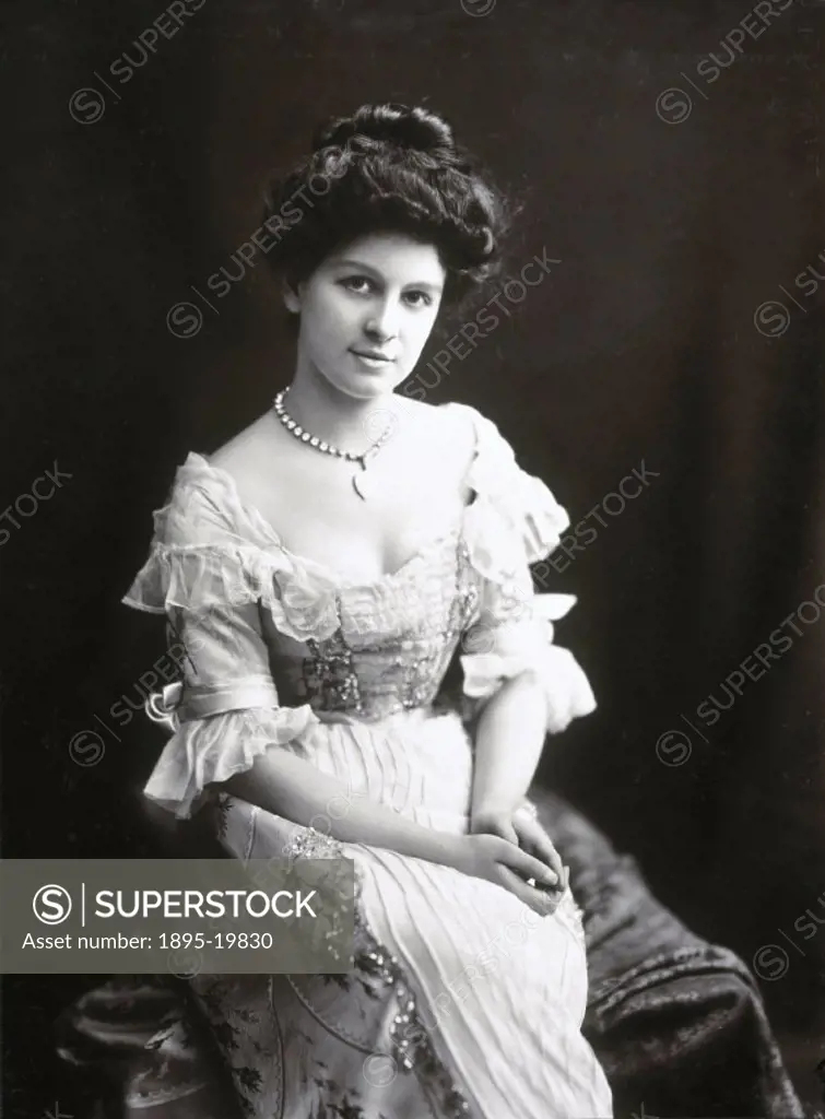 Young woman sitting in an elaborate dress,  1890s.