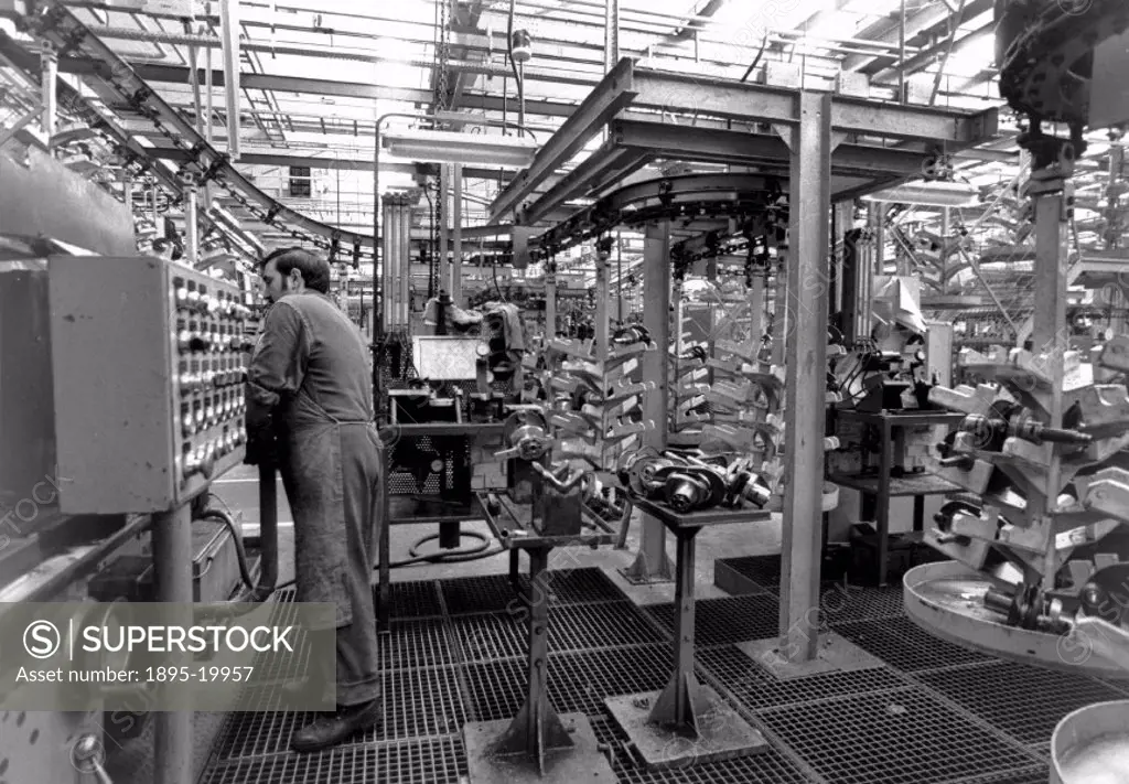 Photograph by Nick Thompson showing a worker operating a machine on a production line manufacturing the Citroen 2CV. The first 2CV prototype was produ...