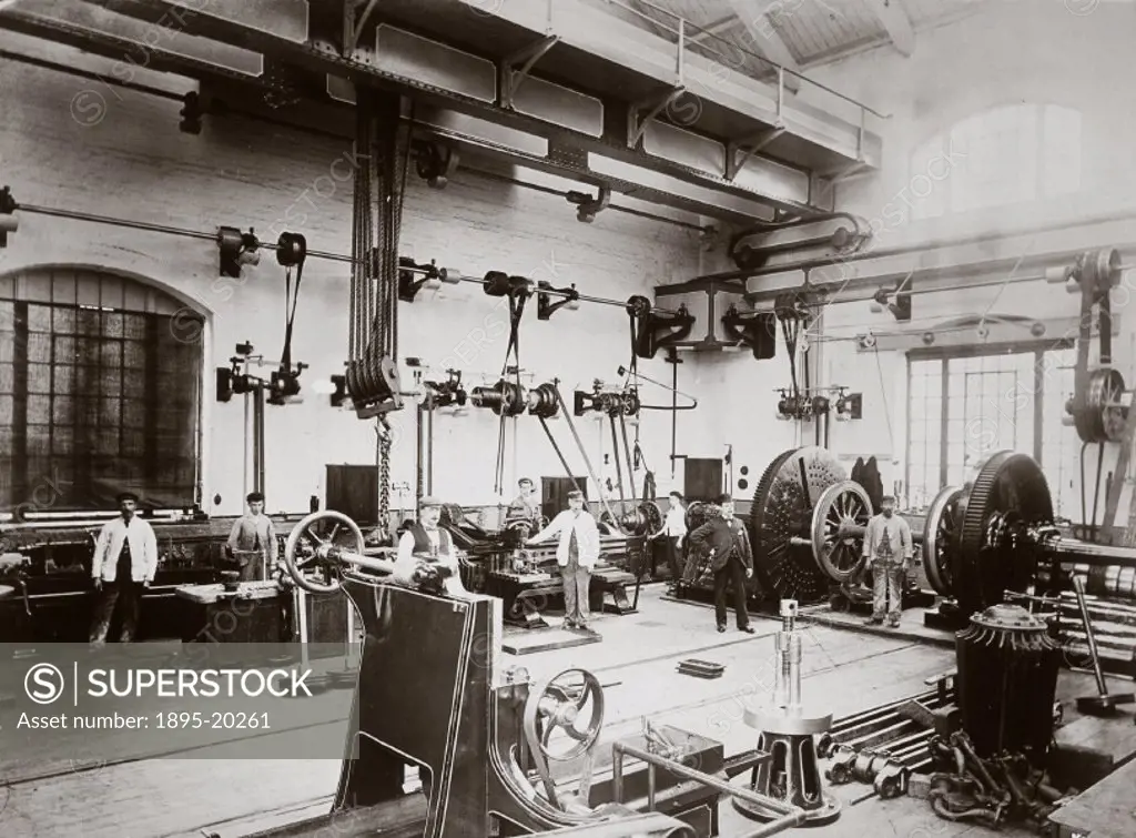 Workers pose alongside machine tools, driven by belts running from shafts connected to the power house at the Midland railways workshop in Wellingbor...