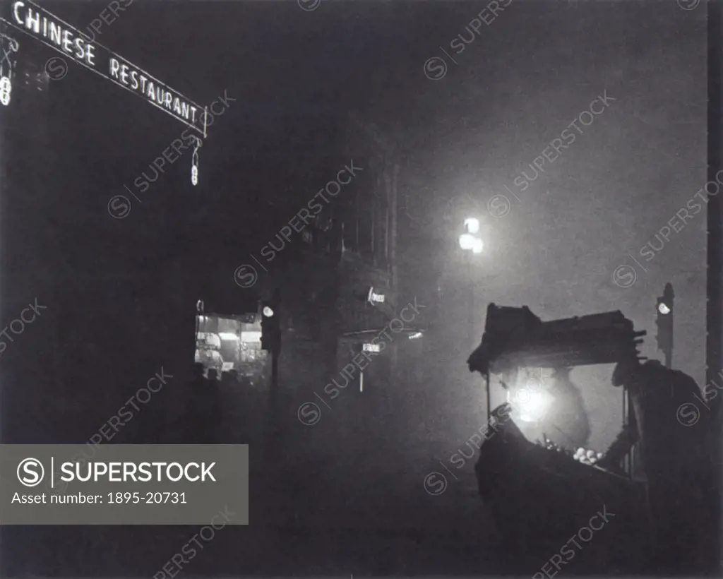 ´A foggy Piccadilly partially lit by the light from a fruit seller´s stall, 1952.