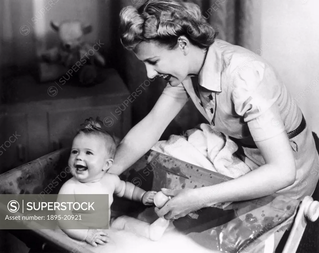 Woman bathing a baby, 1940s