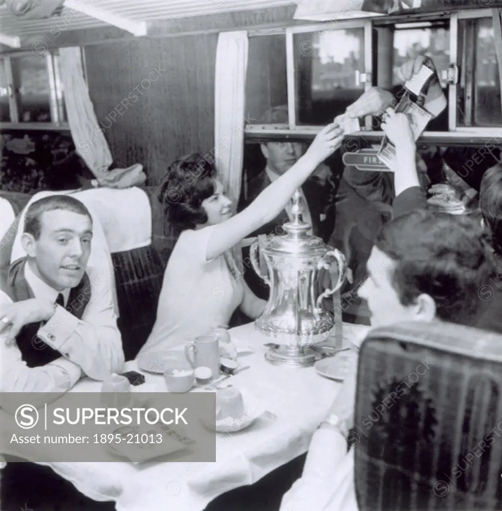 Ian St John (left) with others sitting at a railway carriage table with a trophy on 2 May 1965. Ian St John (b 1938) was a Scottish footballer who sta...