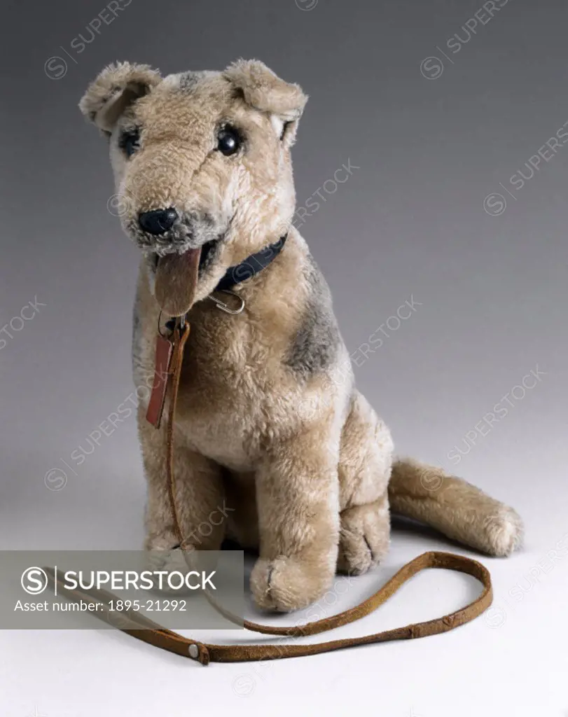 Childs toy in the shape of a furry dog, with collar and lead.