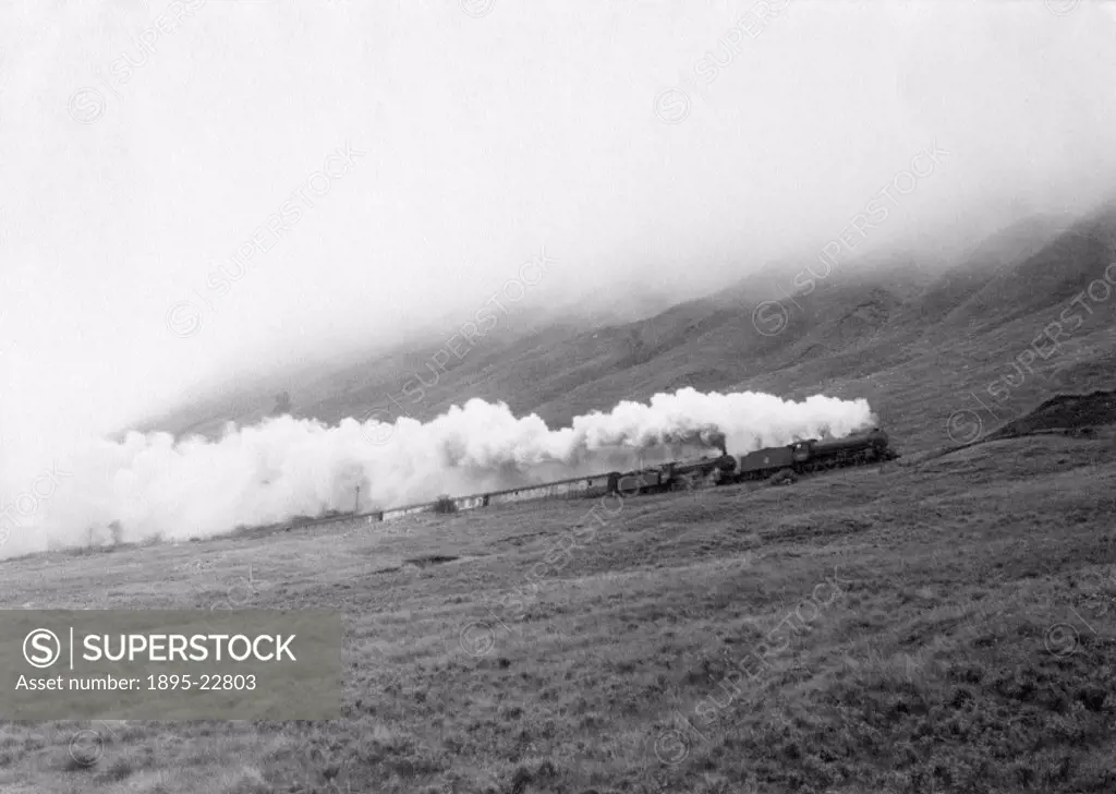 Photograph by Cyril Herbert showing a steam locomotive pulling an express train up a steep gradient in the West Highlands of Scotland.