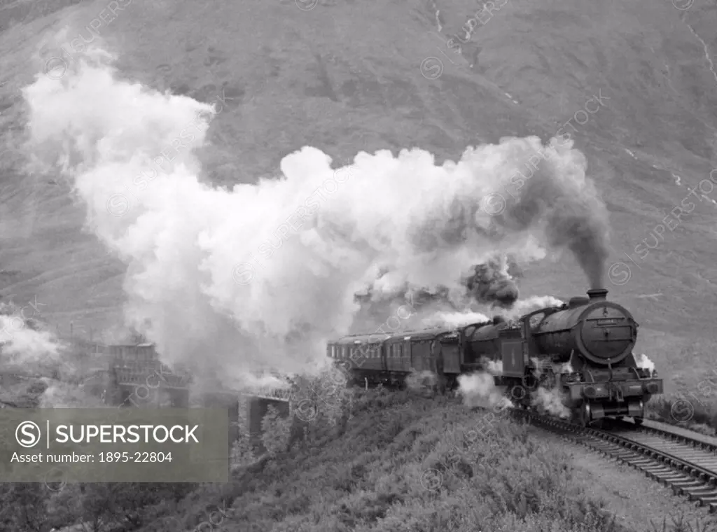 Photograph by Cyril Herbert showing a steam locomotive pulling an express train in the West Highlands of Scotland.
