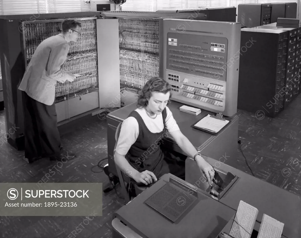 Man and woman shown working with an IBM type T04 electronic data processing machine used for making computations for aeronautical research at the NACA...