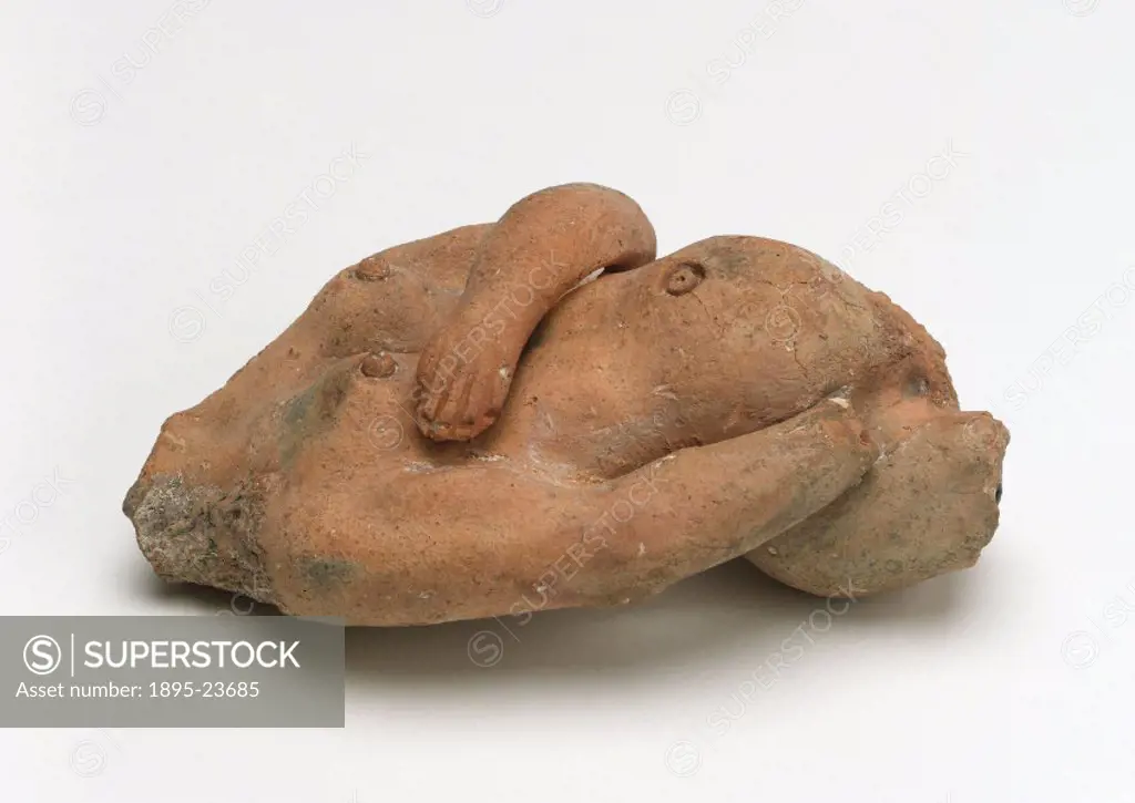Torso of a pregnant female figure made from terracotta, said to have been found in Suffolk. Side view.