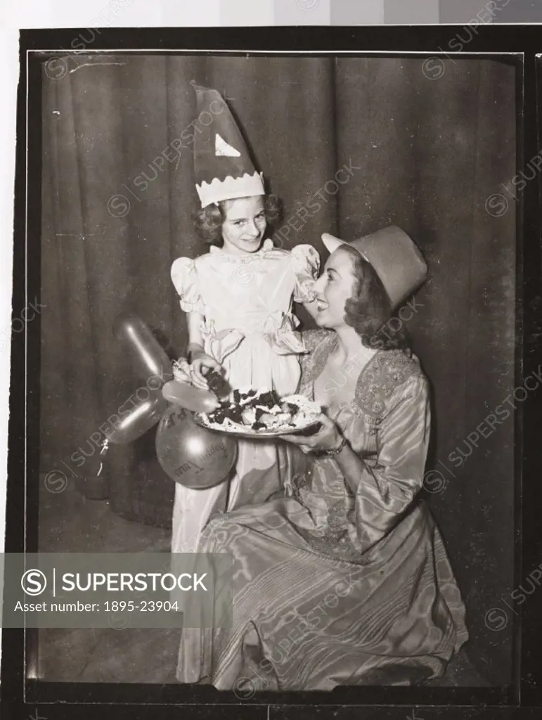 Vera Lynn and nine-year-old Hester Goldstein at a Christmas party for men, women and child victims of infantile paralysis. The party was held on 11 De...