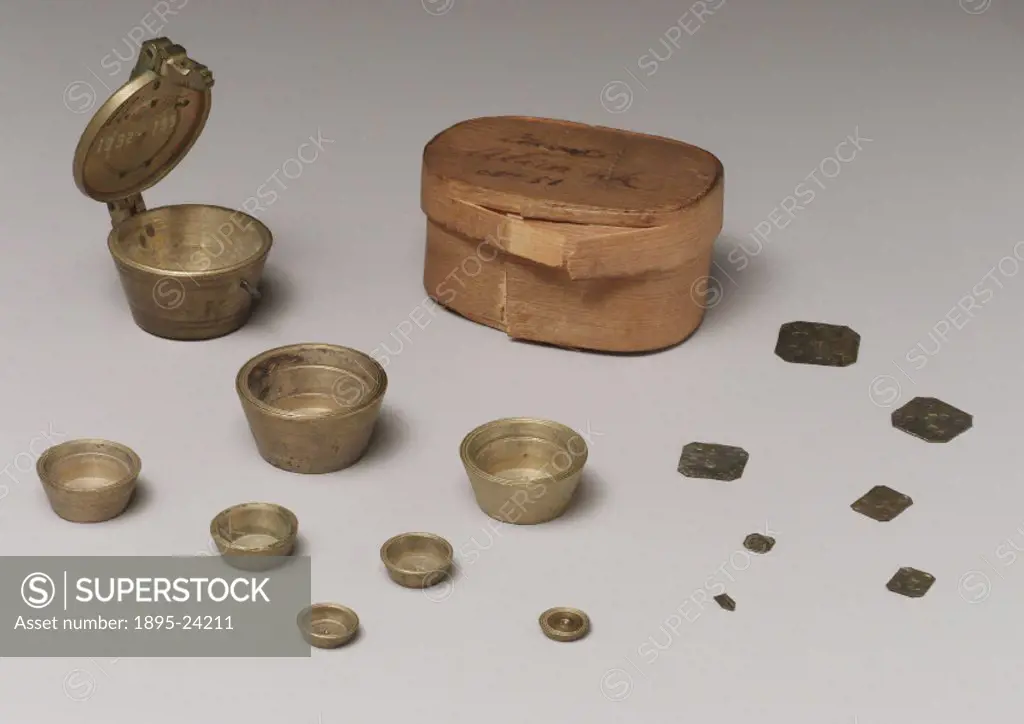 Set of brass nested cup weights with box and a selection square grain weights used for general weighing in the district of Alicante in Spain. These we...