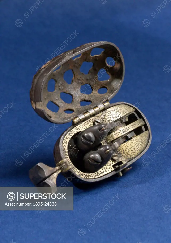 A tiny Japanese tinder pistol in an egg-shaped, fenestrated, pierced metal case with twin arms and twin steel. This device has been ingeniously adapte...