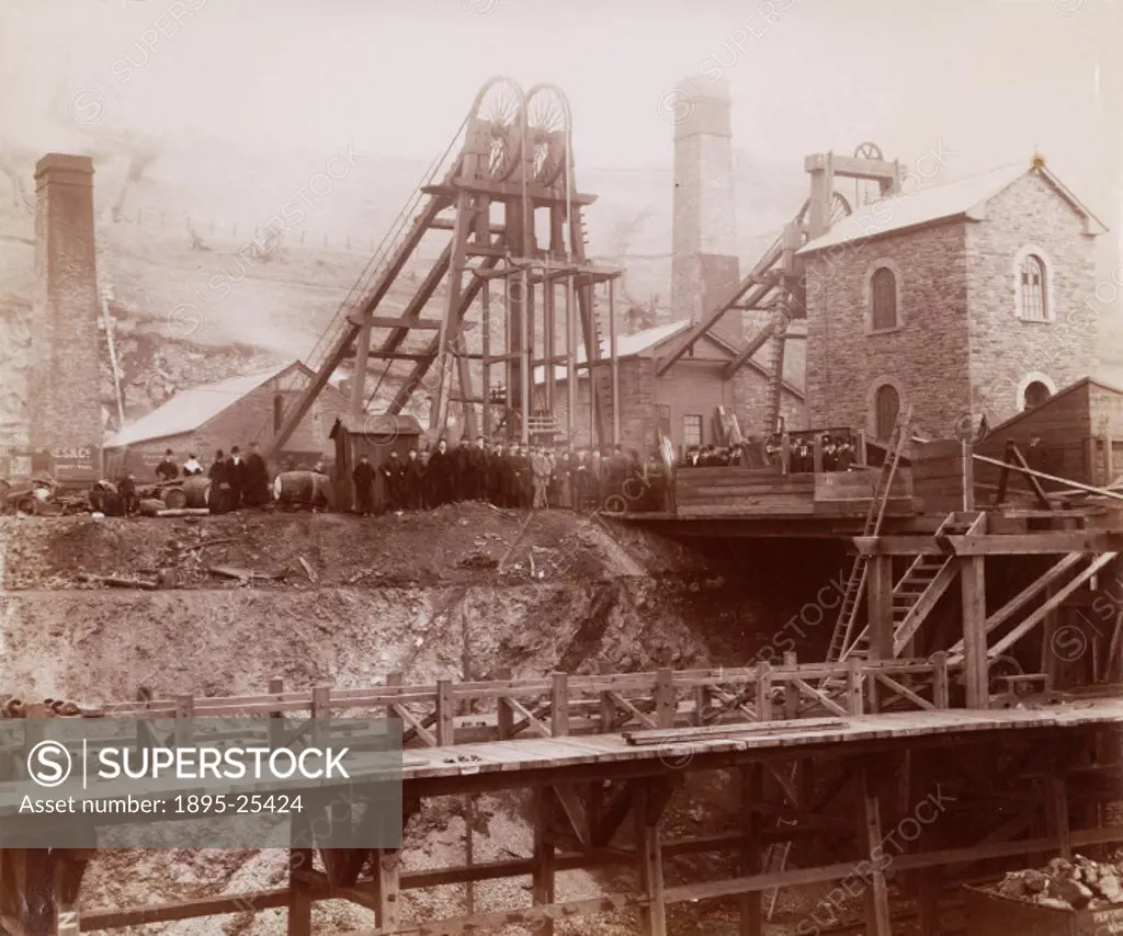 Albumen photographic print showing the pit head, winding gear and coal trucks of a colliery at Ponsy Pool. Miners can be seen assembled around the pit...