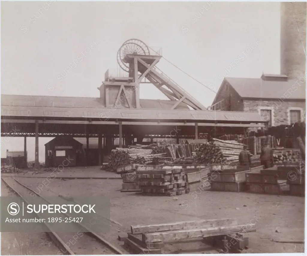 Albumen photographic print showing a yard at a pit head including wooden sleepers, wooden pit props and winding gear.