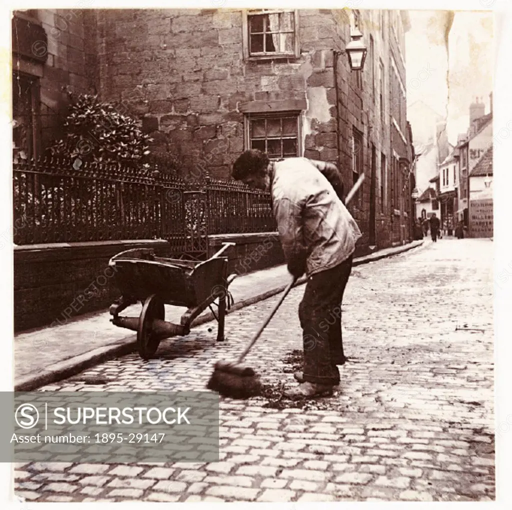 Photograph by Frank Meadow Sutcliffe (1853-1941). With his cart and shovel at the side of the cobbled street, the man sweeps up what is most likely ho...