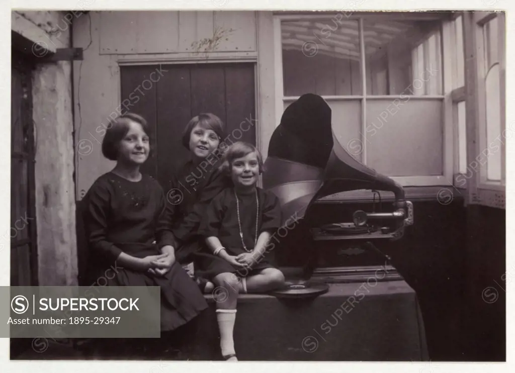 A snapshot photograph of three girls sitting beside a gramophone, taken by an unknown photographer in about 1925.  Originally a shooting term, the wor...