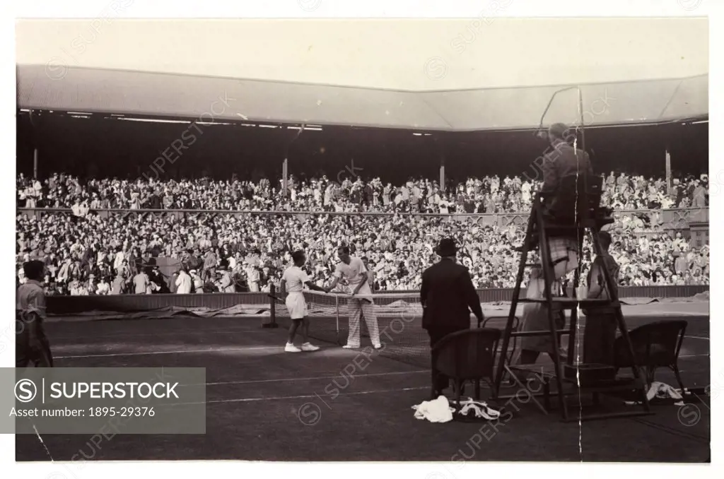 A snapshot photograph of two tennis players at Wimbledon, taken by an unknown photographer in 1936.  Fred Perry (1909-1995) is photographed here winni...