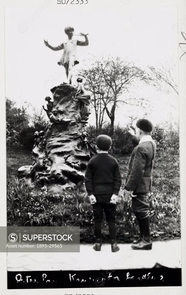 A snapshot photograph of the statue of Peter Pan in Kensington Gardens, London, taken by an unknown photographer in about 1915.  Two young boys are lo...