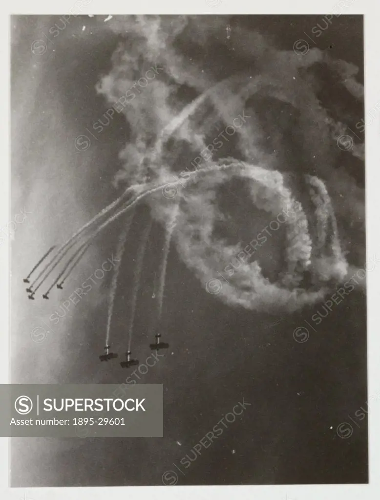 A snapshot photograph of biplanes trailing smoke as part of an aerobatics display, taken by an unknown photographer in about 1935.  Originally a shoot...