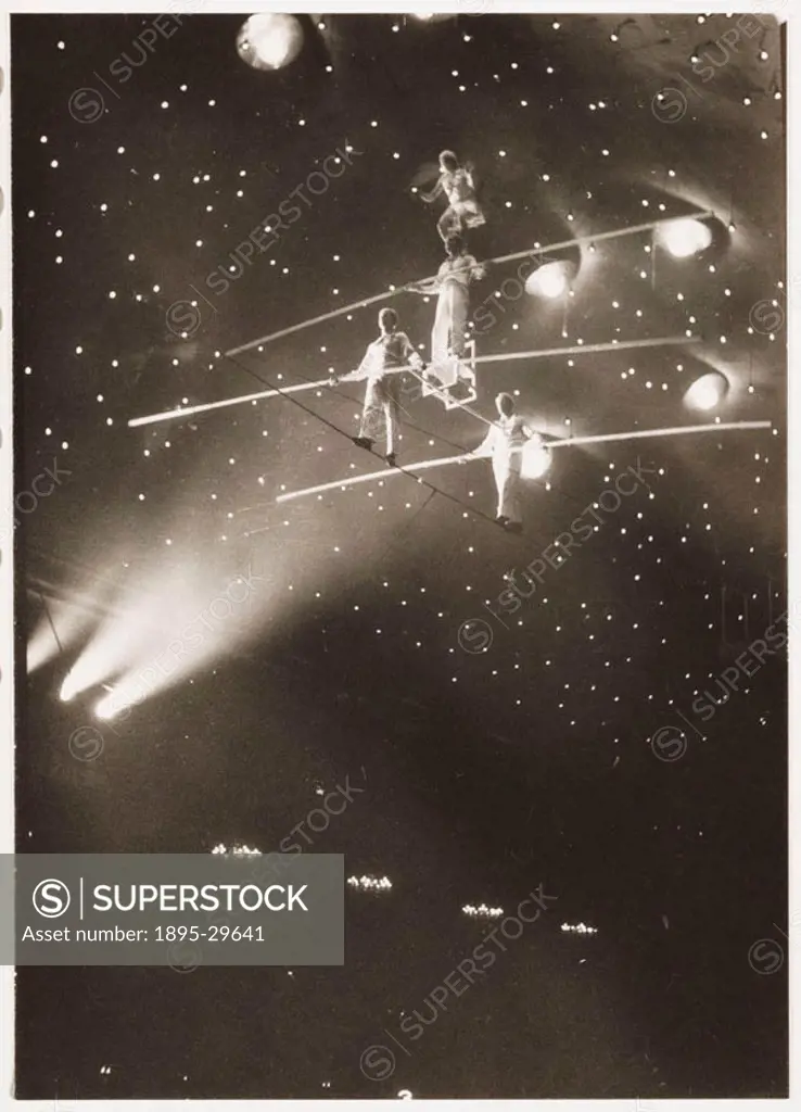 A snapshot photograph of a group of acrobats inside a circus big top walking on tightropes, taken by an unknown photographer in about 1930.  Originall...