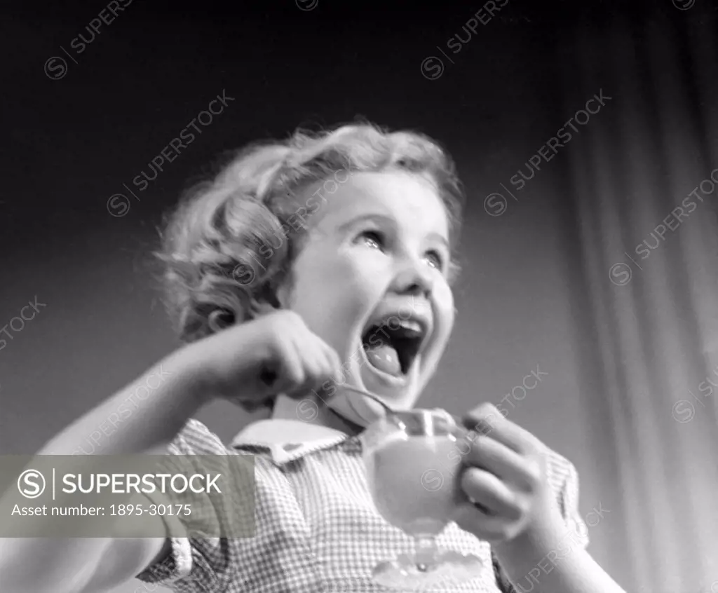 A photograph of a laughing little girl eating dessert, taken by Photographic Advertising Limited in 1950.  Images of children often feature in the wor...
