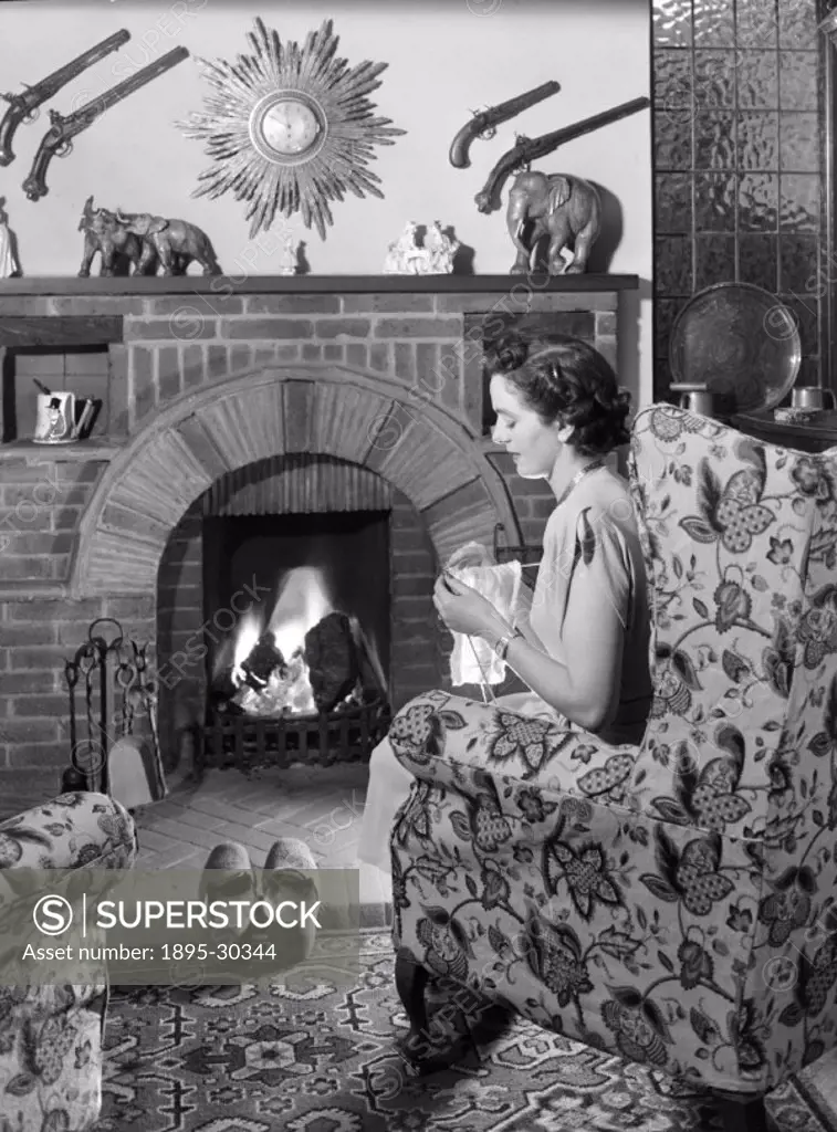 A photograph of a woman knitting in front of the fire, taken by Photographic Advertising Limited in about 1950.  Photographic Advertising Limited was ...
