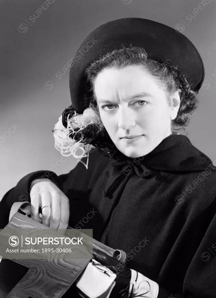 A photograph of a woman reaching into her handbag, taken by Photographic Advertising Limited in 1949.  The photograph was used in an election campaign...