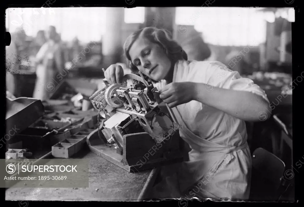 Woman building a radio set on an assembly line at the HMV (His Master´s Voice) works at Hayes, Middlesex. The chassis of the radio is held at an angle...