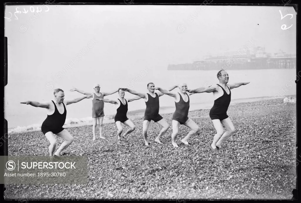 A photograph of a group of men in swimsuits exercising on Brighton beach, taken by James Jarche (1891-1965) for the Daily Herald newspaper on 4 Septem...