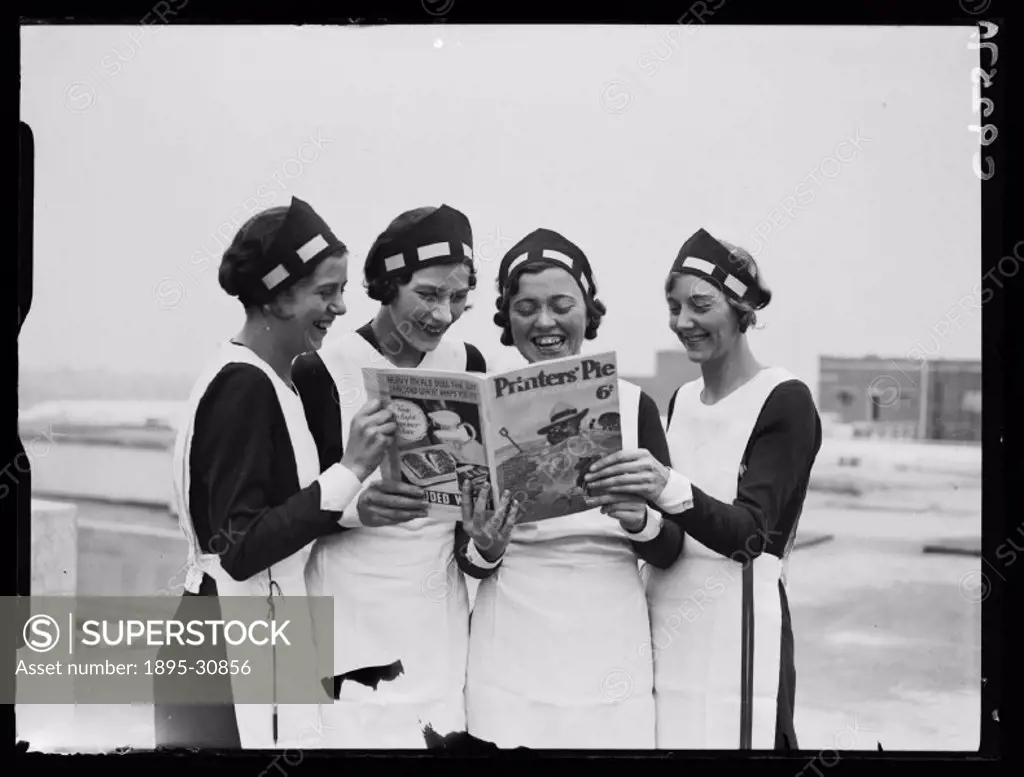 A photograph of four women happily reading a holiday annual magazine, taken by James Jarche (1891-1965) for the Daily Herald newspaper on 12 July, 193...