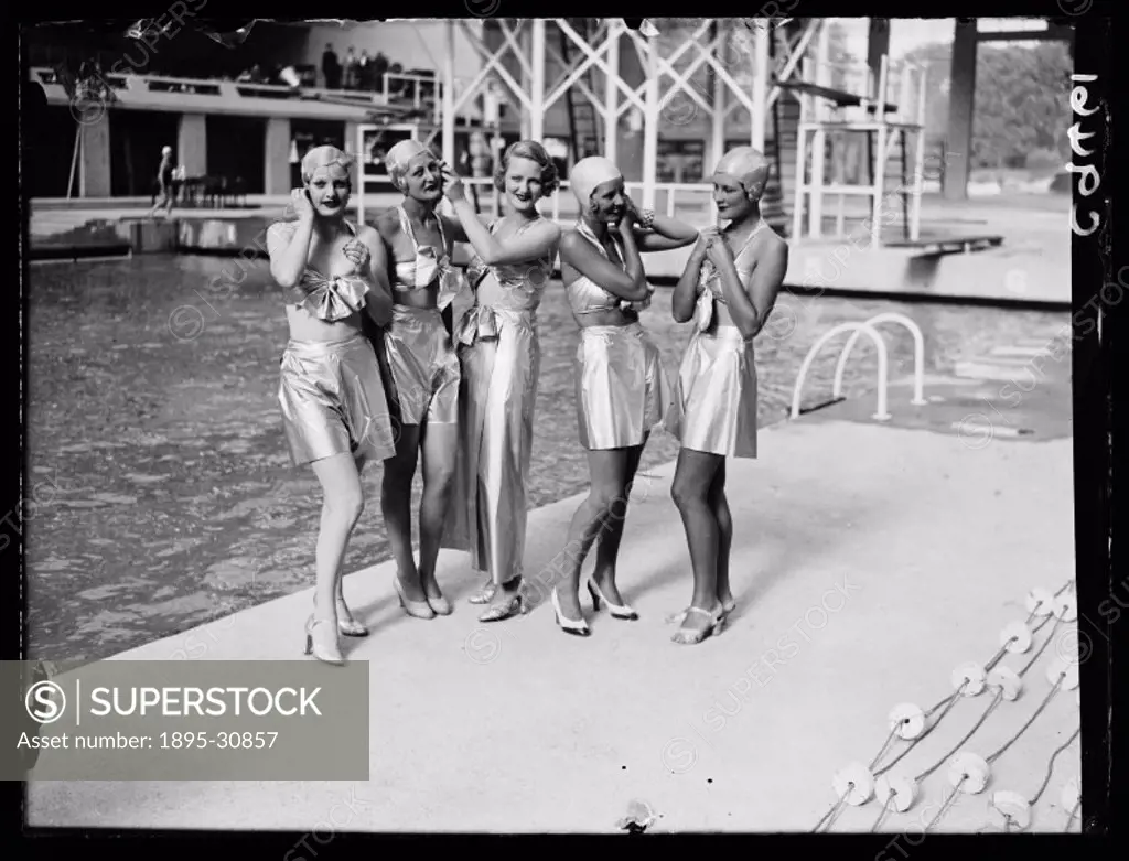 A photograph of a group of women dressed in futuristic swimwear by a pool, taken by Edward Malindine for the Daily Herald newspaper on 27 July, 1934. ...